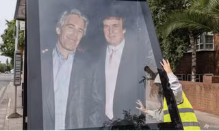 Các nhà hoạt động dựng bức ảnh cỡ lớn mà ông Trump chụp với Epstein trước Đại sứ quán Mỹ ở London ngày 17/7. (Ảnh: AP)