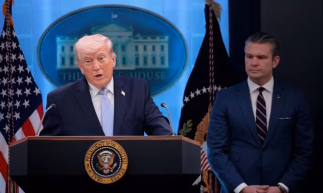 Tổng thống Trump đứng cạnh Bộ trưởng Chiến tranh. (Ảnh: Reuters)