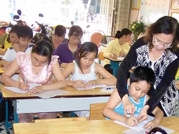 Cô Uyên đang hướng dẫn cho học viên tập viết chữ đẹp. Ảnh: H.Phương (Thanh Niên)