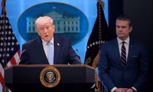Tổng thống Trump đứng cạnh Bộ trưởng Chiến tranh. (Ảnh: Reuters)