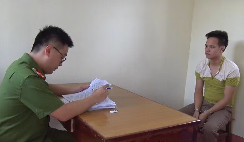 Đối tượng Hoàn (bìa phải) tại cơ quan công an .Ảnh: Minh Anh