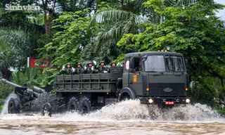 Người dân lội nước cổ vũ dàn xe khí tài quân sự vượt đường ngập 