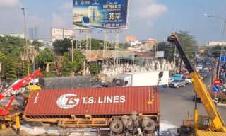 Xe container bất ngờ lật ở vòng xoay, sơn đổ trắng mặt đường lúc rạng sáng
