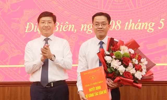 Phó Bí thư Tỉnh ủy Mùa A Vảng trao Quyết định và tặng hoa chúc mừng tân Chánh Văn phòng Tỉnh ủy Trịnh Hoàng Thắng. Ảnh: Lan Phương.