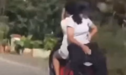 Hai nữ sinh 'làm xiếc' trên xe máy điện