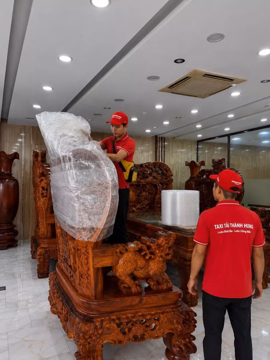 Đội bốc xếp Thành Hưng mặc áo đỏ in logo tại một ca chuyển nhà. Ảnh: Thành Hưng