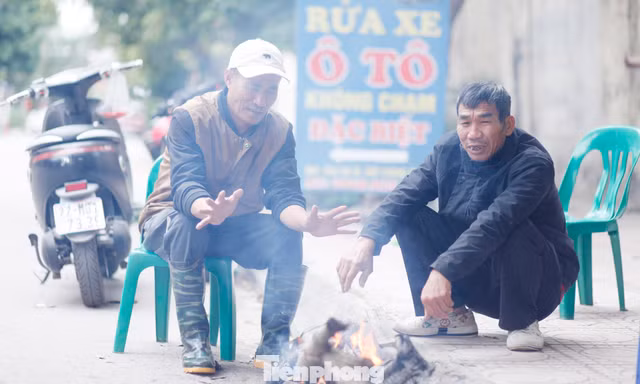 Ông Đỗ Văn Thủy (bên trái) nhóm lửa sưởi ấm. Ảnh: Nguyễn Thắng