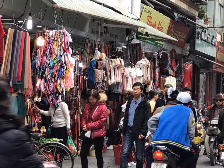 người dân và du khách phải đi bộ dưới lòng đường Phố Đinh Liệt vì viar hè đã bị lấn chiếm kinh doanh quần áo