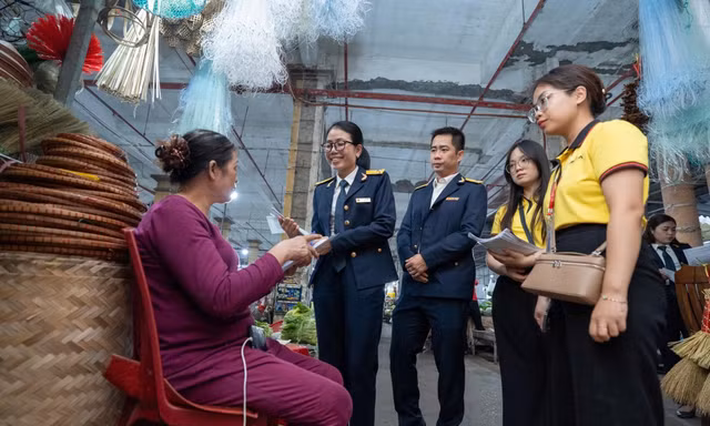Cán bộ thuế đi tới từng quầy hàng tuyên truyền, hỗ trợ tháo gỡ vướng mắc.