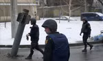 Lực lượng Ukraine đứng gần một rocket bị mắc kẹt ở Kharkiv ngày 25/2. (Ảnh: Reuters)