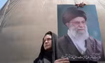 Một người dân giương cao ảnh chân dung Đại giáo chủ Iran trong cuộc biểu tình tại Tehran ngày 13/6. (Ảnh: AP)