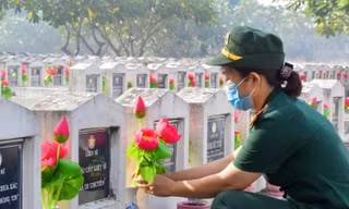 Nữ chiến sỹ thay hoa mộ liệt sỹ