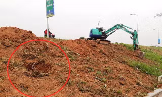 Hình ảnh máy xúc múc các hố để chôn lấp rác, gạch đá vào thân đê