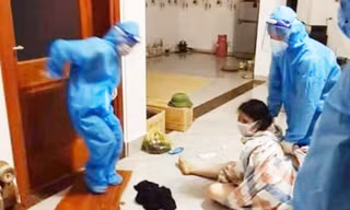 Lực lượng chức năng phải quấn bạt đưa người phụ nữ đi cách ly