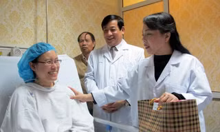 Bộ trưởng Y tế Nguyễn Thị Kim Tiến (phải) chúc bác sĩ Hạnh sớm khỏe để trở lại với công việc