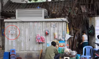 Mặc dù có biển cảnh báo nguy hiểm, không được lại gần ( ở vòng tròn đỏ) tại bốt điện này, nhưng người bán hàng nước và vị khách này vẫn ngồi sát. Ảnh chụp tại vỉa hè phố Vũ Tông Phan