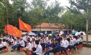 Học sinh trường Tiểu học Bán trú Vừ A Dính che dù dự lễ khai giảng.