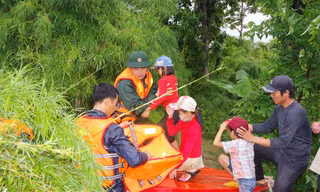 Chiến sĩ Đoàn Kinh tế - Quốc phòng 737 dùng ca nô đưa trẻ em ra khỏi vùng ngập lụt.