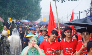 Đội mưa xem đua thuyền trên sông Pheo