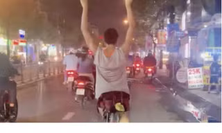 Người đàn ông lái xe đạp buông hai tay trên phố ở TPHCM