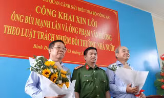 Thượng tá Đặng Trọng Cường tặng hoa cho ông Lân (trái) và Hướng (phải) tại buổi công khai xin lỗi. Ảnh: Tân Châu