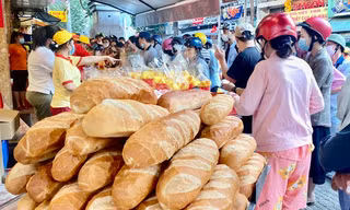 Xếp hàng từ tờ mờ sáng để mua heo quay cúng Thần Tài