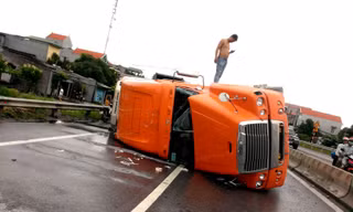Container chồm lên dải phân cách rồi lật ra đường