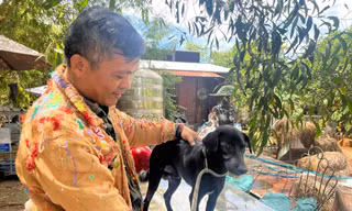 Họa sĩ Nguyễn Quốc Dân đang làm thủ tục “phóng sinh” một chú chó sắp bị đưa vào lò mổ