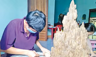 Anh Lê Ngọc Thanh đang tỉ mỉ xoi trầm miếng tại nhà