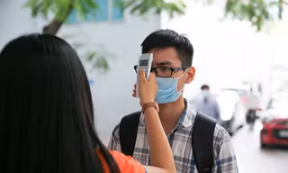 Sinh viên được đo thân nhiệt trong ngày đầu trở lại trường sau gần 1 tuần nghỉ học phòng dịch