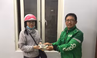 Anh Huy (bên phải) trao lại số tiền 100 triệu đồng cho người đánh rơi. Ảnh người dân cung cấp.