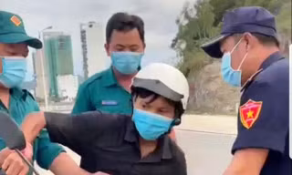 Anh Trần Văn Em (người đội mũ bảo hiểm trắng) bị cán bộ phường Vĩnh Hoà giữ xe khi đi mua bánh mì. Ảnh chụp lại clip