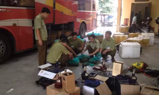 Lực lượng chức năng kiểm đếm số rượu ngoại không nhãn mác. Ảnh: NT