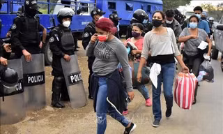 Cảnh sát Guatemala ngăn chặn người di cư trong hành trình tới Mỹ tại khu vực Cofradia, Honduras, ngày 15/1/2021. Ảnh: THX/TTXVN