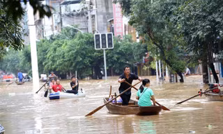 Lũ lụt dâng cao khiến người dân phải chèo thuyền đi lại ở huyện Dung Thủy, tỉnh Quảng Tây. Ảnh: Xinhua