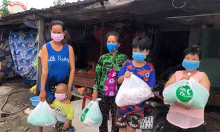 Chị Trần Thị Thu Trúc (bìa trái) vui mừng vì nhận được phần thực phẩm thiết yếu
