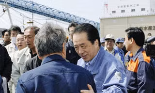 Thủ tướng Naoto Kan nói chuyện với quan chức thủy sản tỉnh Miyagi ngày 10-4 khi thăm một cảng cá ở địa phương này bị động đất, sóng thần tàn phá Ảnh: Kyodo