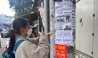 Sinh viên tìm thông tin phòng trọ trên tờ rơi dán trước cổng Trường ĐH Giao thông vận tải TPHCM. Ảnh: Nhàn Lê