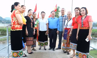 Nhà báo Lê Minh Toản - Phó Tổng Biên tập báo Tiền Phong cùng người dân đi trên chiếc cầu tạm ngày khởi công cầu ở huyện Con Cuông (Nghệ An)