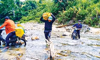 Đoàn viên thanh niên Huyện Đoàn Nam Giang băng rừng, lội suối vận chuyển vật liệu xây “Mái ấm biên cương”. Ảnh: Nguyễn Thành