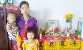 Vợ và con anh Sang trước di ảnh chồng. Ảnh: Hòa Hội.