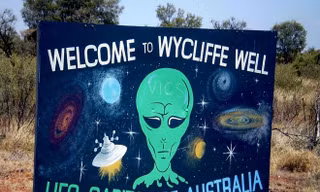 "Chào mừng tới Wycliffe Well, thủ đô UFO của Australia" là nội dung một tấm biển báo bên lề một đường cao tốc dẫn tới thị trấn Wycliffe Well.