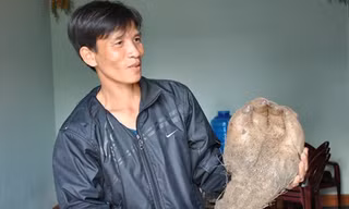 Anh Quyền đang cầm củ khoai có hình bàn tay.