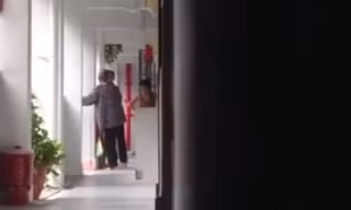 Bà cụ sức khỏe yếu thường xuyên phải vịn tay vào tường. Ảnh cắt ra từ clip.