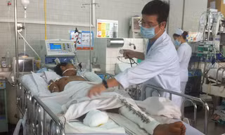 Bác sĩ Huy đang thăm khám cho anh Tám tại khoa hồi sức cấp cứu Bệnh viện Chợ Rẫy. Ảnh: Quốc Ngọc.