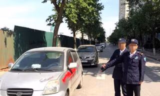 Nhóm bảo vệ xịt sơn vào xe ô tô đỗ dưới lòng đường.