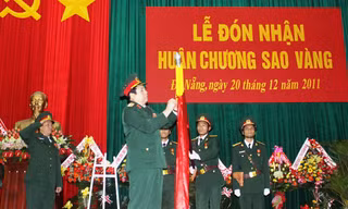 Đại tướng Phùng Quang Thanh gắn Huân chương Sao Vàng lên quân kỳ quyết thắng của Quân khu 5. Ảnh: Nguyễn Huy