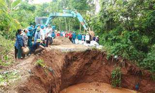 Lực lượng tại chỗ của xã Bột Xuyên, huyện Mỹ Đức (thành phố Hà Nội) xử lý sự cố sập cống xả qua đê hữu Đáy. Ảnh: HNM