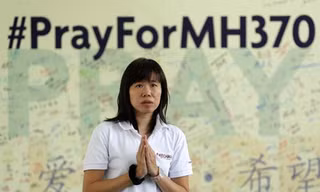 Một phụ nữ ở ngoại ô Kuala Lumpur cầu nguyện cho những người mất tích trên chuyến bay MH370. Ảnh: Reuters