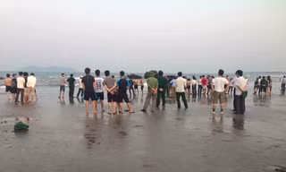 Người dân tập trung nơi bãi biển xảy ra vụ hai học sinh bị sóng cuốn mất tích khi đi chụp ảnh kỷ yếu.